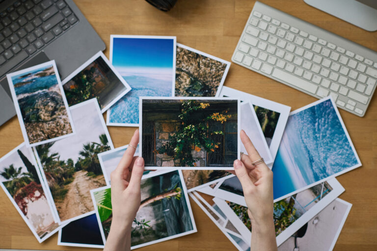 High angle view of photographer examining her professional photos while sitting at her workplace with computers