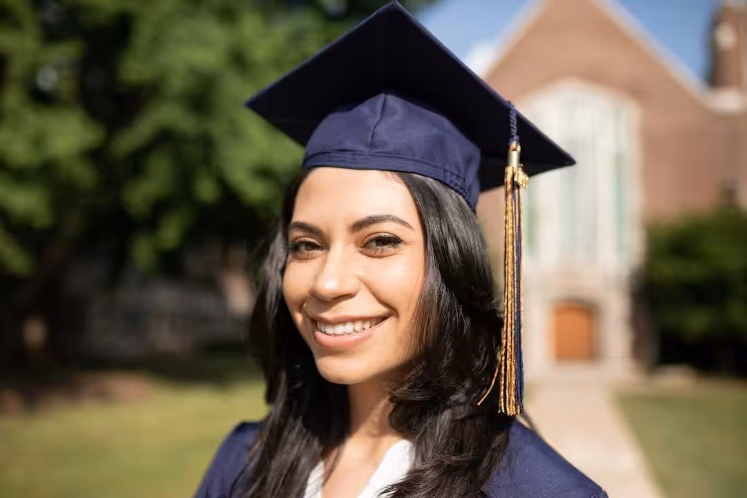Giovane donna laureata con toga e tocco durante la cerimonia di laurea