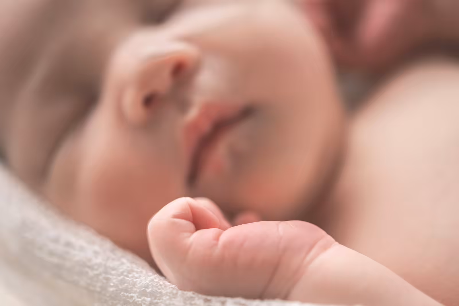 Foto di un neonato che dorme su una coperta bianca
